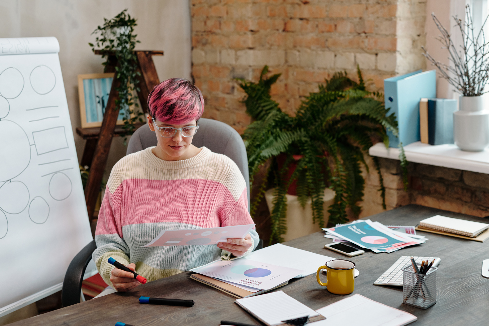 Woman in White Pink and Blue Sweater Sitting on Gray Chair